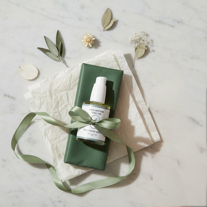 Face Matters Skincare Face Food Serum bottle with dropper, wrapped in green paper and ribbon on a marble surface.